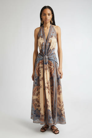 Woman wearing a long, patterned dress on a white background