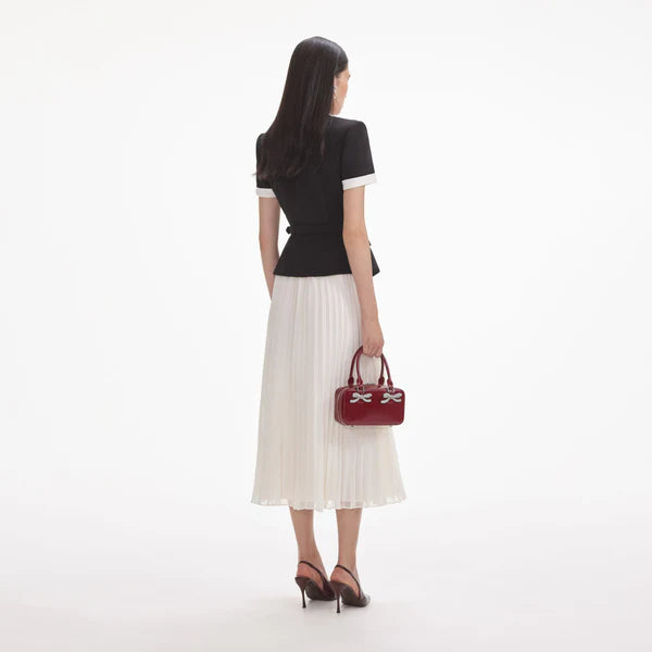 Woman holding a red handbag with a white background