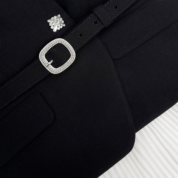 Black coat with decorative silver buckle and earring on a white background