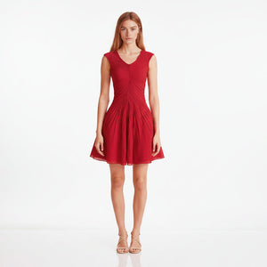 Red dress worn by a model on a light pink background