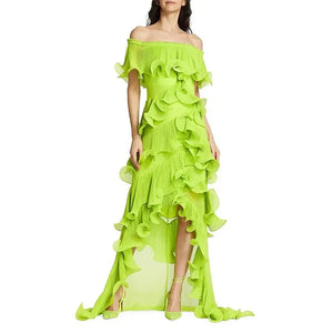 Woman wearing a bright green off-shoulder ruffled dress on a white background