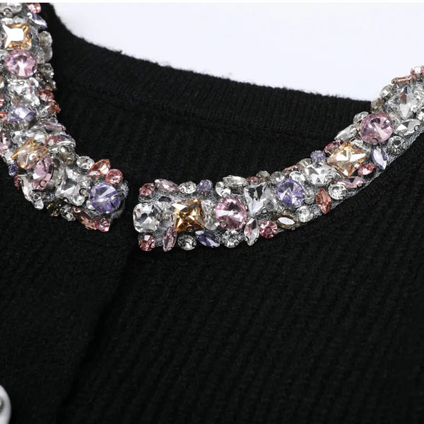 Black sweater with a decorative multicolored gemstone collar on a white background