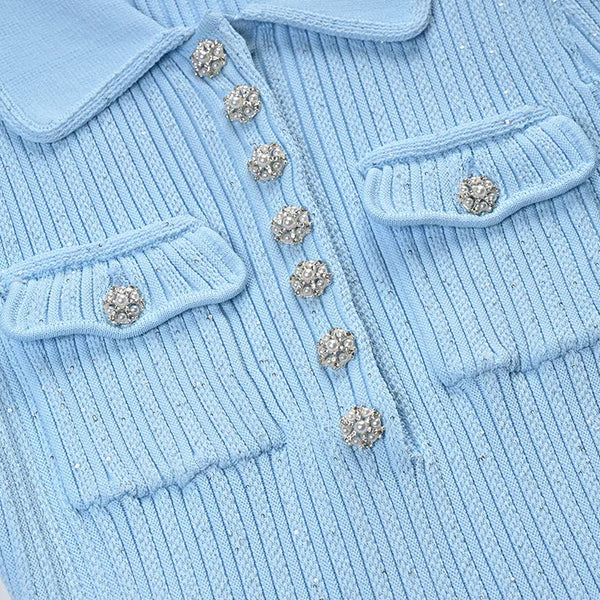 Light blue ribbed sweater with decorative buttons on a white background