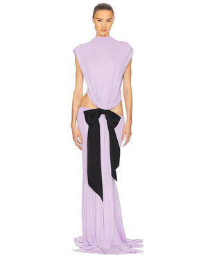 Woman wearing a lavender dress with a black bow on a white background