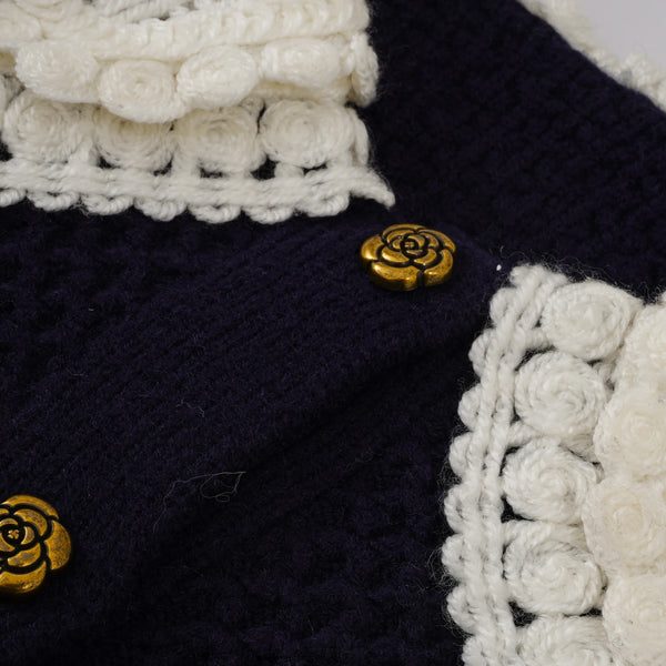 Navy blue fabric with white crocheted trim and gold rose buttons