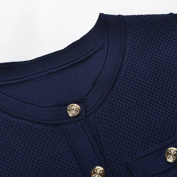 Navy blue textured garment with gold buttons on a light gray background