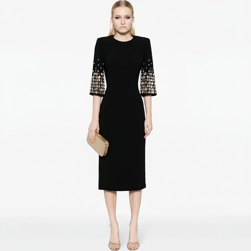 Black dress with patterned sleeves worn by a model on a white background