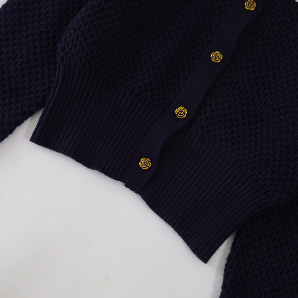 Navy blue cardigan with gold buttons on a white background