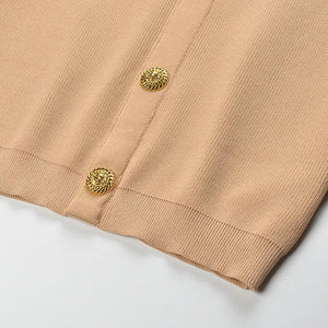 Close-up of beige fabric with gold buttons on a white background