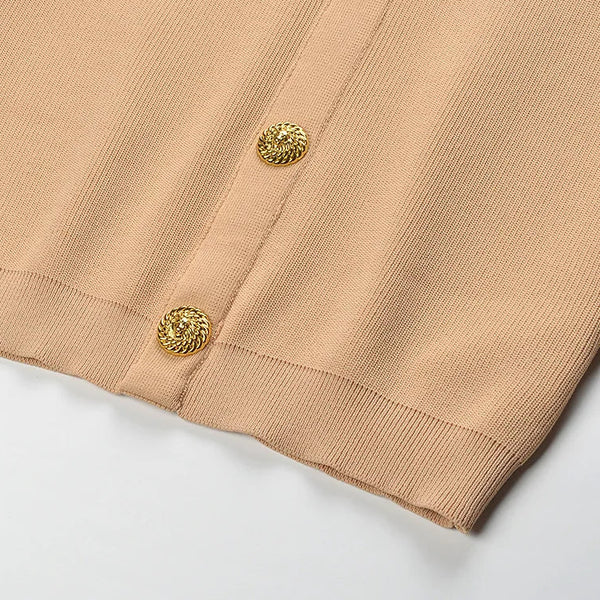 Close-up of beige fabric with gold buttons on a white background
