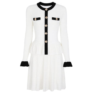 White dress with black accents and buttons on a white background
