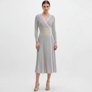 Woman wearing a long-sleeve, striped dress on a white background