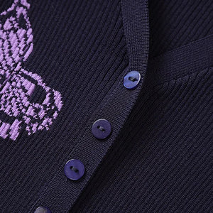 Close-up of a dark blue cardigan with purple embroidered design and buttons.