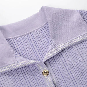 Close-up of a light purple ribbed sweater with white trim on a white background
