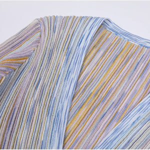 Close-up of a multicolored striped fabric with blue, yellow, and purple hues.