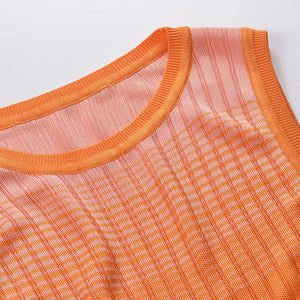 Close-up of an orange sleeveless garment with a checkered pattern on a light gray background