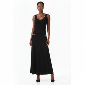 Woman wearing a black dress with pearl embellishments on a white background