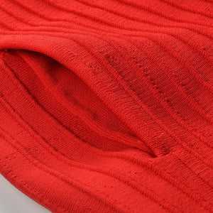 Close-up of red fabric with a ribbed texture on a light gray background