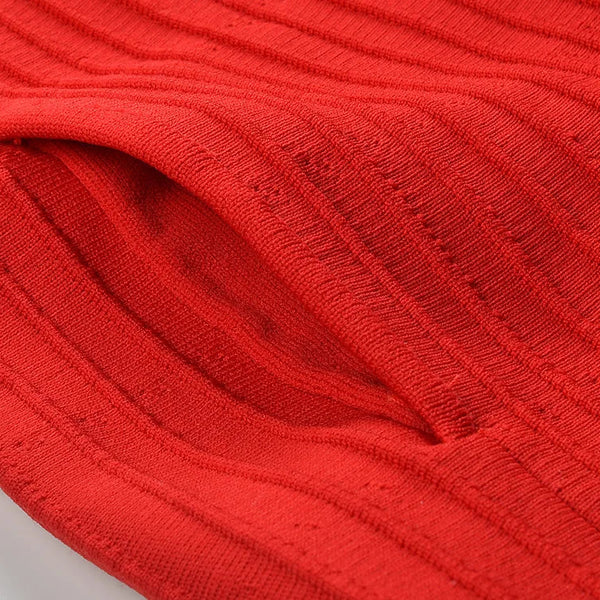 Close-up of red fabric with a ribbed texture on a light gray background