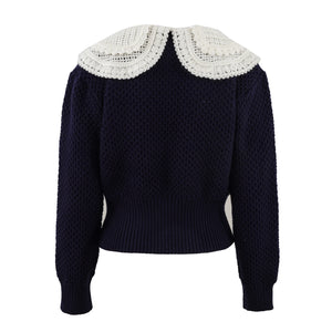 Navy sweater with white lace collar on a white background