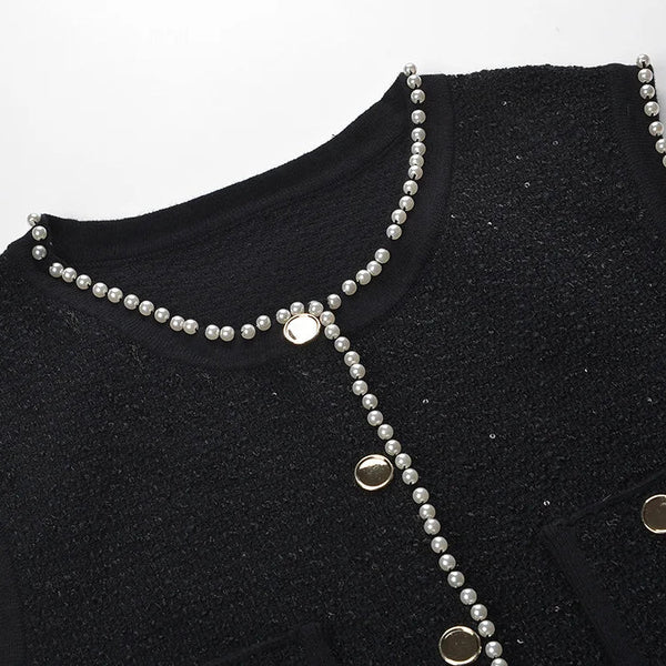 Black garment with silver beaded details on a white background