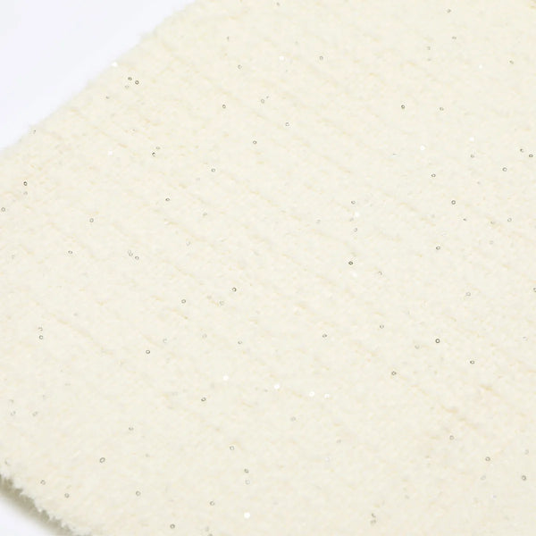 Close-up of a textured beige fabric with a subtle pattern on a white background