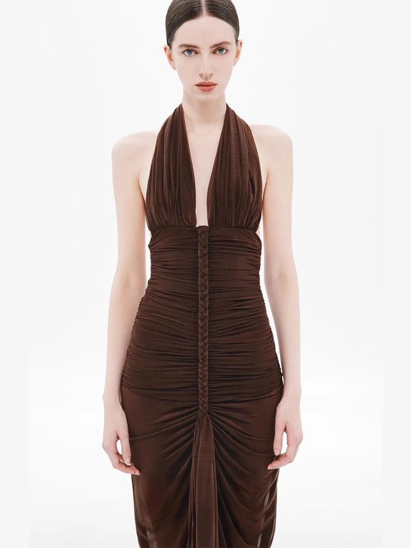 Woman wearing a brown halter neck dress on a white background