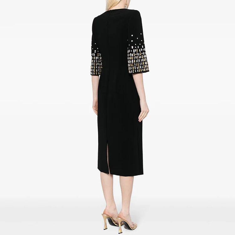 Black dress with patterned sleeves worn by a model on a white background