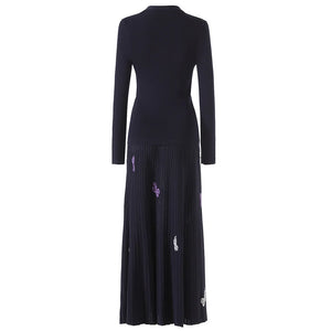 Black dress with floral embellishments on a white background