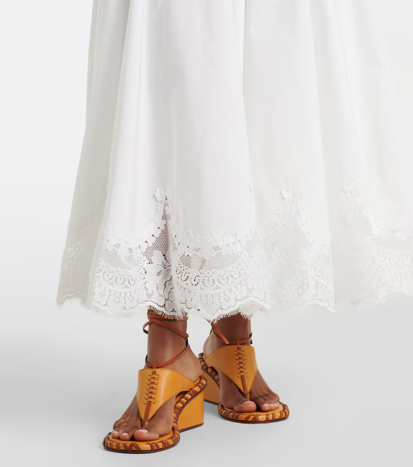 Yellow sandals worn with white lace pants on a white background
