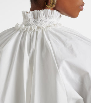White dress with ruffled neckline on a plain background