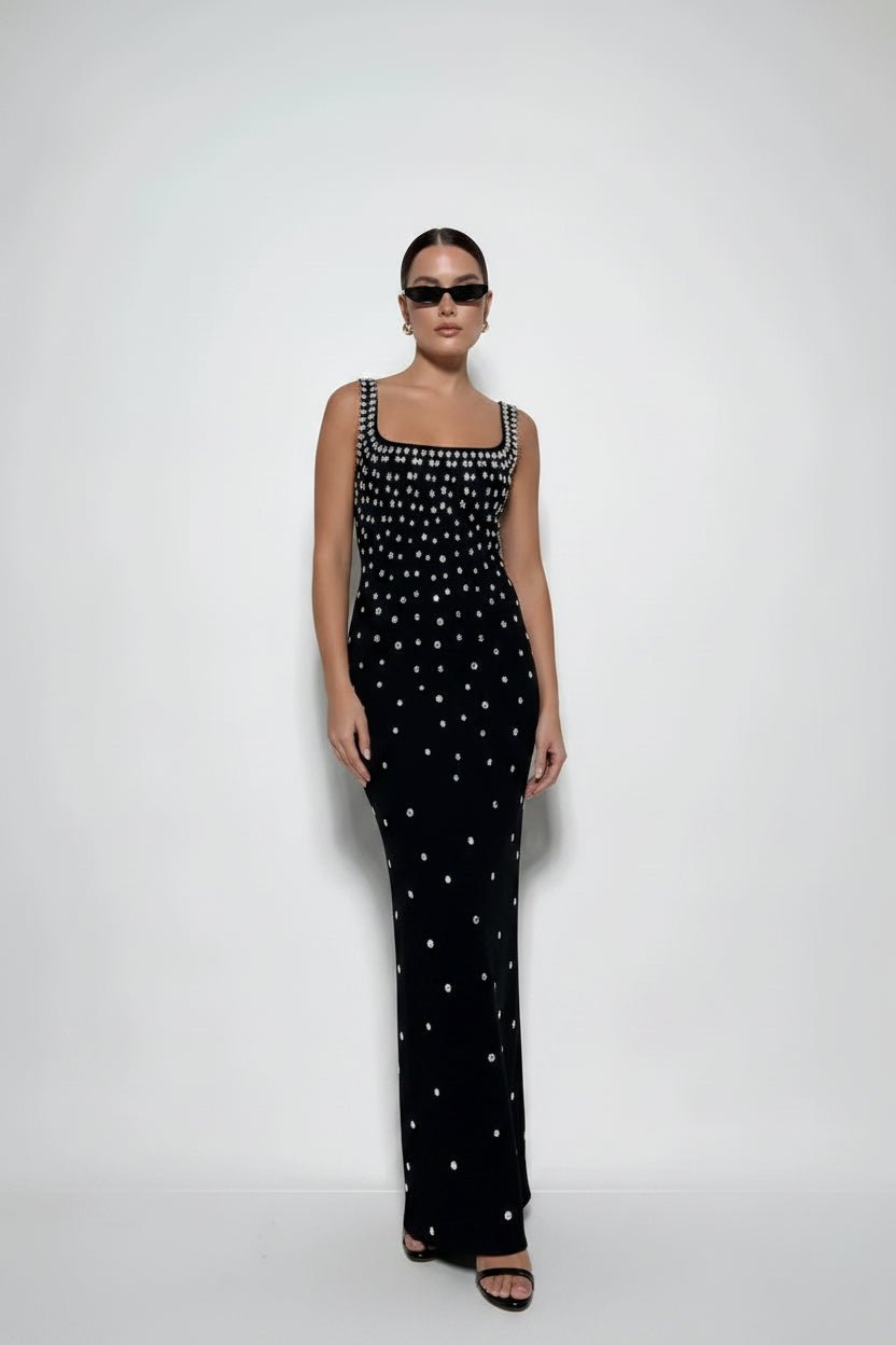 Woman wearing a black dress with white patterns on a white background