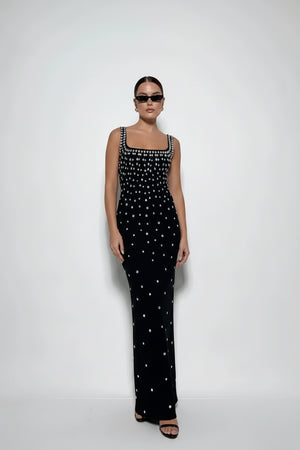 Woman wearing a black dress with white patterns on a white background