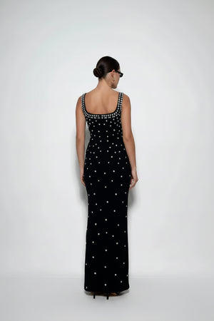 Woman wearing a black dress with white patterns on a white background
