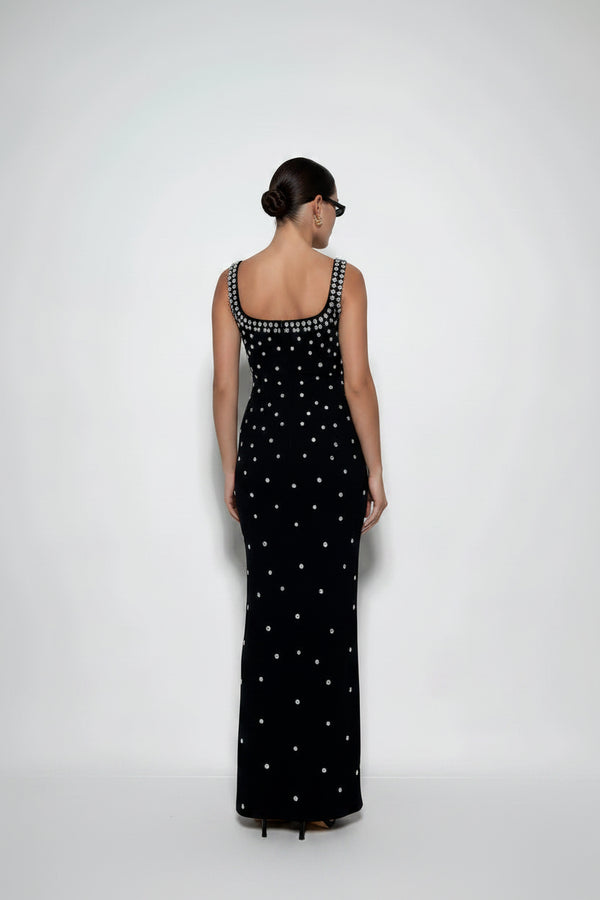 Woman wearing a black dress with white patterns on a white background