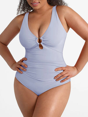 Woman wearing a light blue swimsuit with a decorative button on a white background