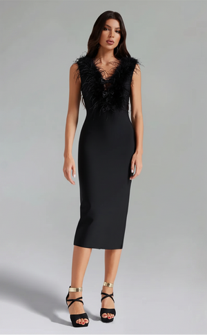 Woman wearing a black dress with feathered details on a gray background