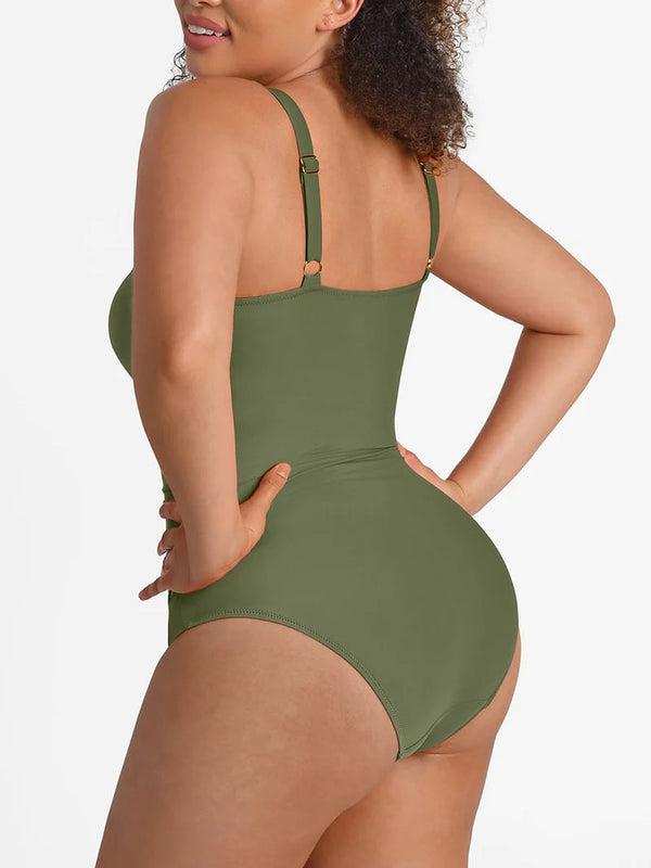 A woman modeling a one-piece swimsuit from the back, showing the solid olive green color and adjustable shoulder straps with small gold-tone hardware, against a clean white background.